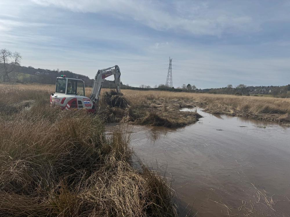 Tractor completing a wader scrape and creating at wetland at Inchgarth Reservoir